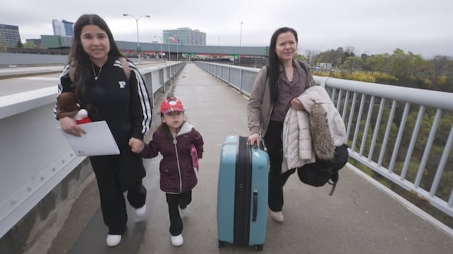 Aracely Serrano, right, with her daughter Itzayana, 4, centre, and Madelin, 14, cross north over the Rainbow Bridge, headed for Niagara Falls, Ont., on their third try to enter Canada.