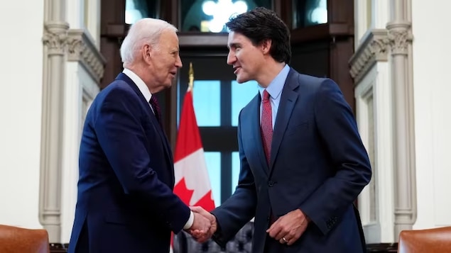 Joe Biden et Justin Trudeau se serrent la main.