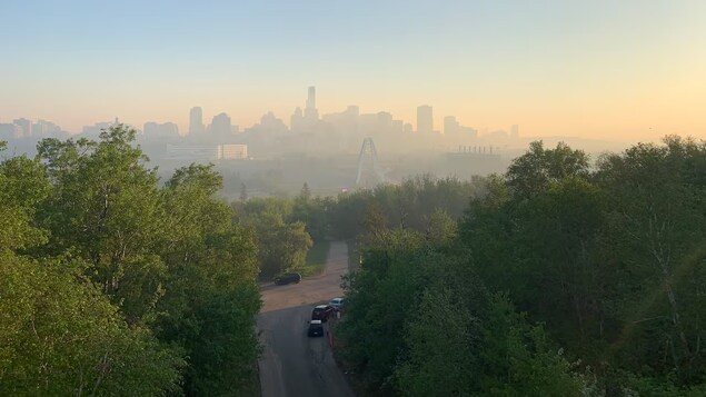 Un halo de fumée enveloppe le centre-ville d'Edmonton, vu d'une colline à la mi-mai 2023.