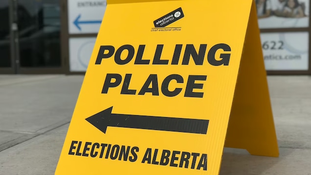 Un cartel de Elections Alberta anuncia una mesa electoral.