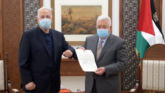 Deux hommes portant un masque posent ensemble.