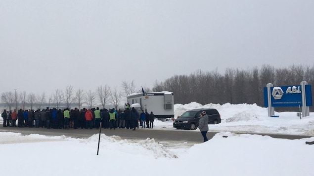 Des travailleurs sont regroupés devant une roulotte installée par le syndicat. Des travailleurs sont regroupés devant une roulotte installée par le syndicat.