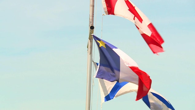 Les drapeaux de l'Acadie, de la Nouvelle-Écosse et du Canada flottent à Tor Bay, en Nouvelle-Écosse.