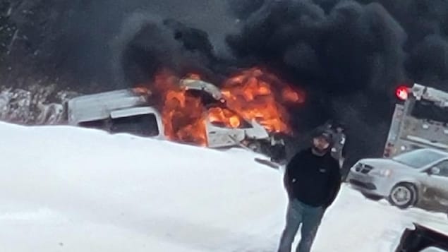 Une voiture brûle dans un fossé.
