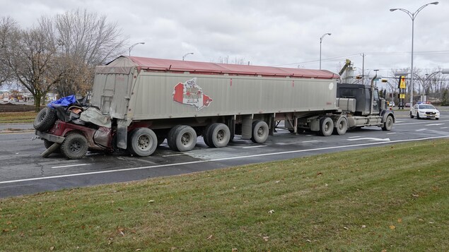 Le véhicule utilitaire sport encastré sous la remorque du camion Le véhicule utilitaire sport encastré sous la remorque du camion