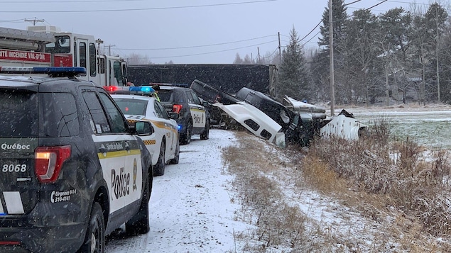 Une camionnette et un fardier en collision dans un fossé sur le bord de la route.
