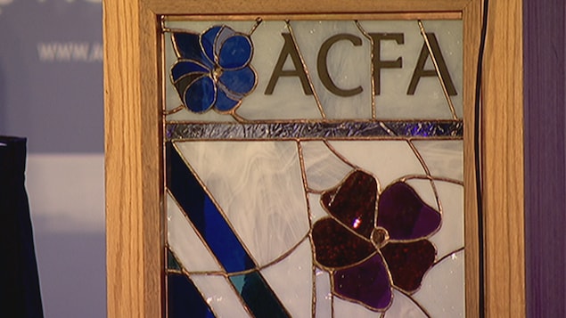 Le logo de l'Association canadienne-française de l'Alberta et le drapeau franco-albertain représentés sous forme de vitrail.