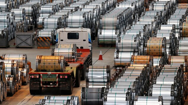 Un camion se faufile entre des rouleaux d'acier Un camion se faufile entre des rouleaux d'acier