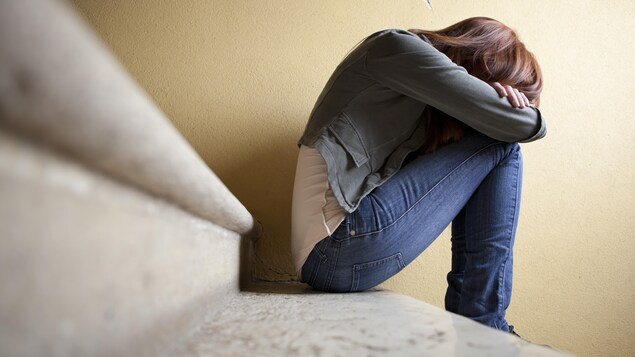 Une adolescente dans un escalier.