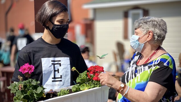 Deux personnes autour d'un bac à fleurs