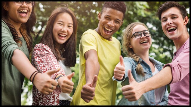 Des adolescents qui lèvent le pouce en l'air et sourient.