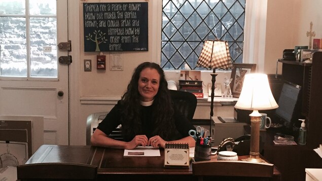 Une jeune femme souriante, assise à son bureau Une jeune femme souriante, assise à son bureau