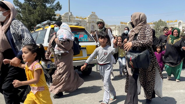 Mujeres y niños intentan entrar en el aeropuerto de Kaboul para salir de Afganistán. 