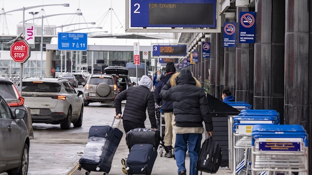 Des voyageurs arrivent au hall des départs d'Air Canada à l'aéroport international Pierre-Elliott-Trudeau de Montréal.