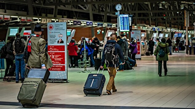 Des voyageurs à l'aéroport d'Ottawa.