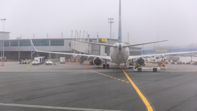 Un avion près du bâtiment de l'aéroport par une journée d'automne grise.