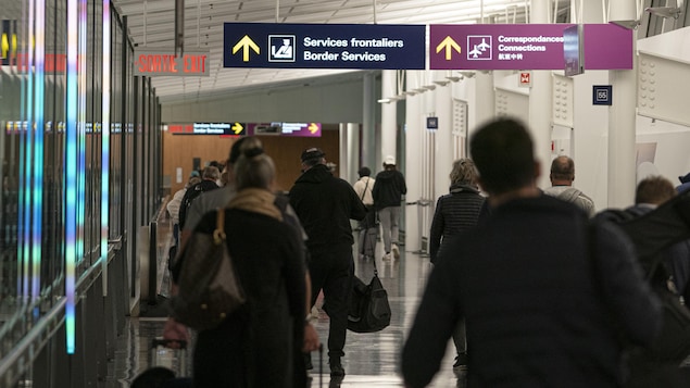 مسافرون واردون إليتوجهون إلى مكتب الجمارك الكندية في مطار ترودو الدولي في مونتريال لدخول البلاد.