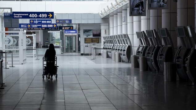 Une femme marche seule dans un corridor de l'aéroport.