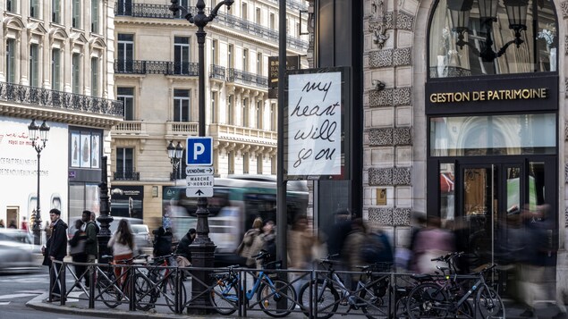 Une affiche est dans une rue.
