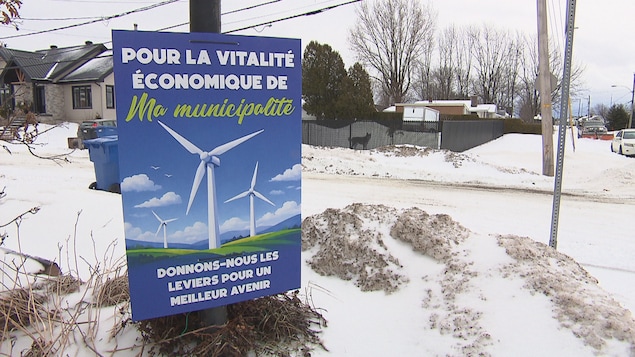 Une affiche est installée contre un poteau et porte l’inscription « Pour la vitalité économique de ma municipalité, donnons-nous les leviers pour un meilleur avenir ».