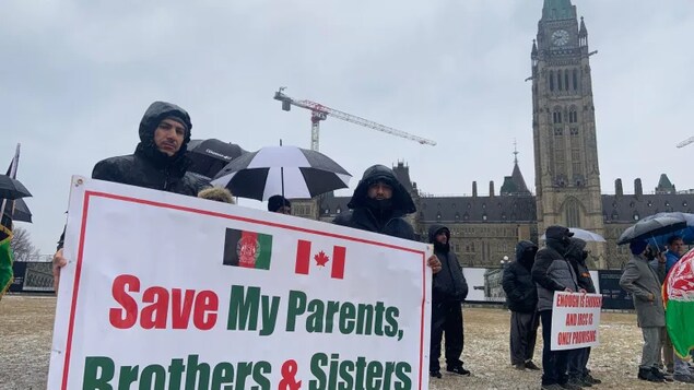 Afghan interpreters braved the cold weather in Ottawa in front of the Centennial Flame as they demonstrated for their loved ones still in Afghanistan. (Raffy Boudjikanian/CBC )