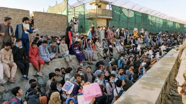 Crowds of people wait outside the airport in Kabul, Afghanistan, on Aug. 25, in this picture obtained from social media.