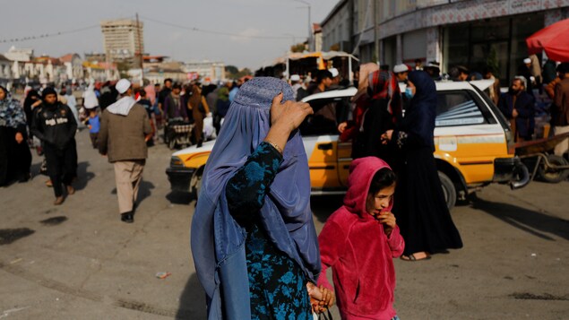 Une femme et une fille afghanes marchent dans une rue de Kaboul.