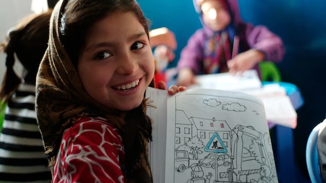 An Afghan girl shows her colouring book at a kindergarten in Mazar-e-Sharif in 2012.