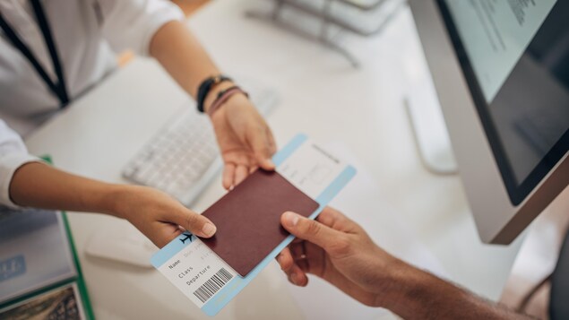 Une femme remet un billet d'avion à un homme.