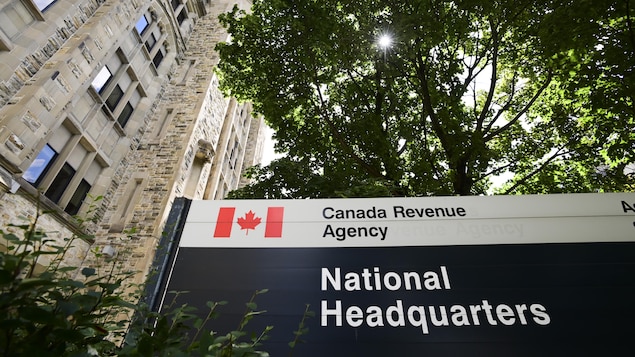 Une pancarte indique l'Agence du revenu du Canada devant un bâtiment de pierres.  