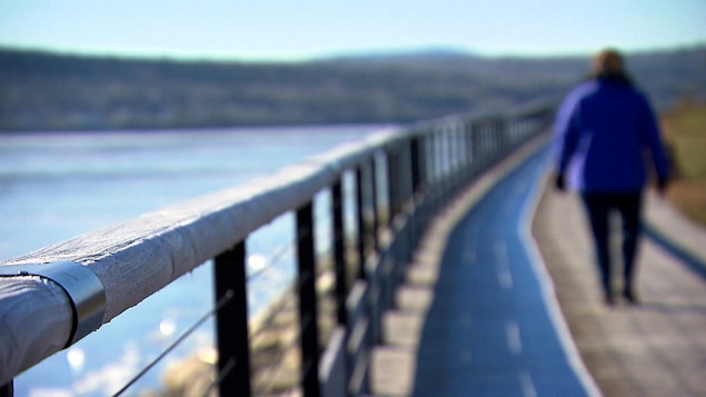 Une femme marche sur le bord de l'eau à Gaspé