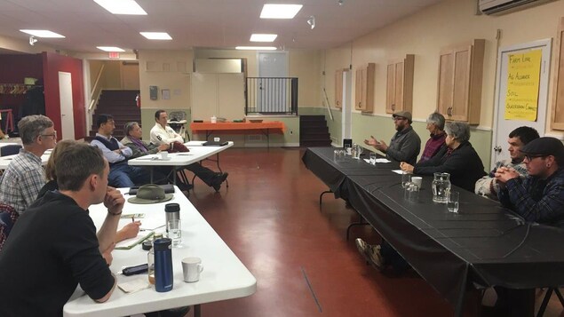 Une dizaine de personnes dans une salle écoutent un conférencier. Une dizaine de personnes dans une salle écoutent un conférencier.