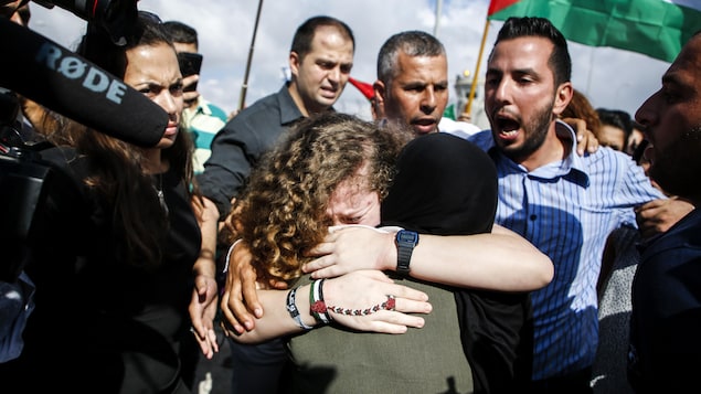 Ahed Tamimi sert une femme dans ses bras, en larmes.