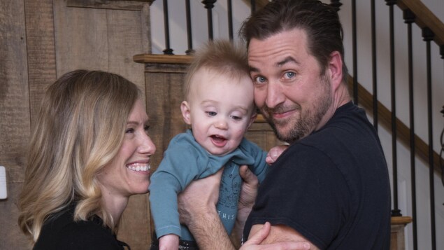 Des parents enlacent leur enfant.
