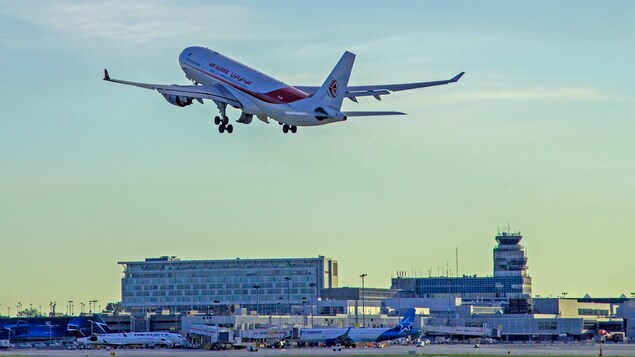Un avion survole un aéroport.