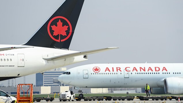 An Air Canada flight taxis on the tarmac at Pierre Elliott Trudeau International Airport in Montreal on May 16, 2022. The airline is reducing its summer schedule by 154 flights. 