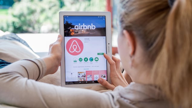 Une femme naviguant sur le site Airbnb.