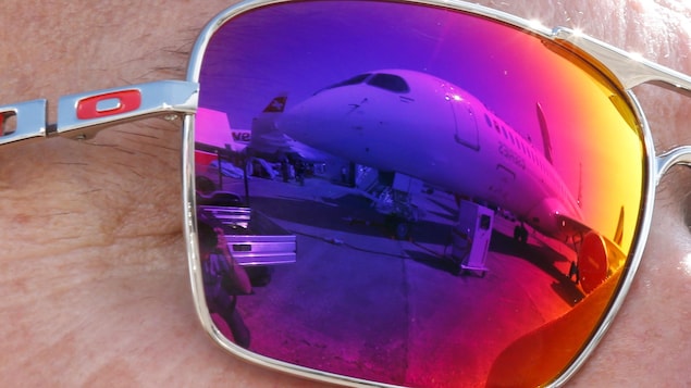 Un avion est visible dans le reflet des lunettes d'un visiteur au salon aéronautique Le Bourget.