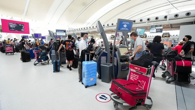Viajeros con maletas haciendo cola en el aeropuerto Pearson.