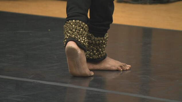 Gros plan sur les pieds d'un danseur portant des rangs de grelots autour de ses chevilles. Gros plan sur les pieds d'un danseur portant des rangs de grelots autour de ses chevilles.