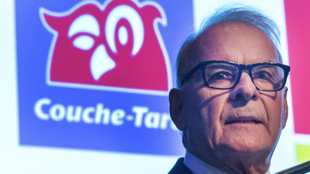 Alain Bouchard devant une projection du logo de Couche-Tard.