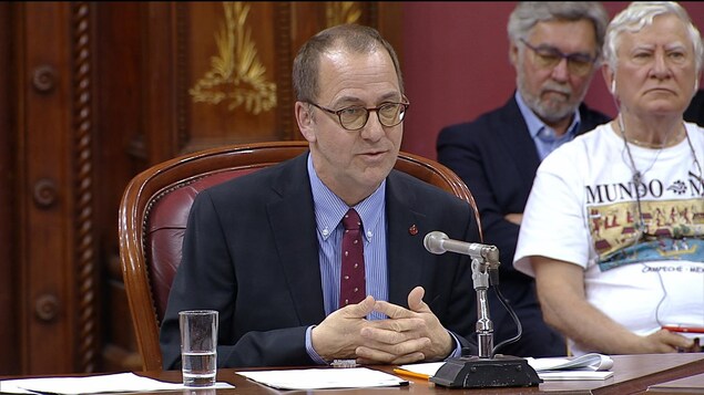 Alain Fortier, les mains jointes, s'adressant aux membres de la commission parlementaire des institutions.