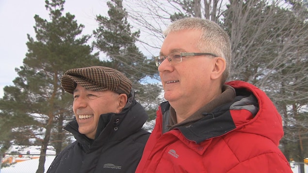 Alain et Nelson sourient en se tenant par les épaules. Alain et Nelson sourient en se tenant par les épaules.