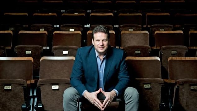 Albert Schultz assis sur des bancs de théâtre dans une salle Albert Schultz assis sur des bancs de théâtre dans une salle