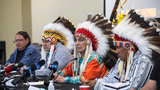 Nakaupo sa harap ng mikropono ang mga chief ng Alberta sa isang press conference.