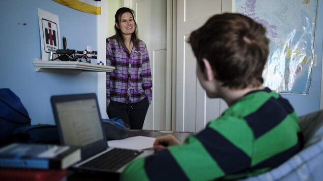 Une mère discute en souriant avec son jeune adolescent.