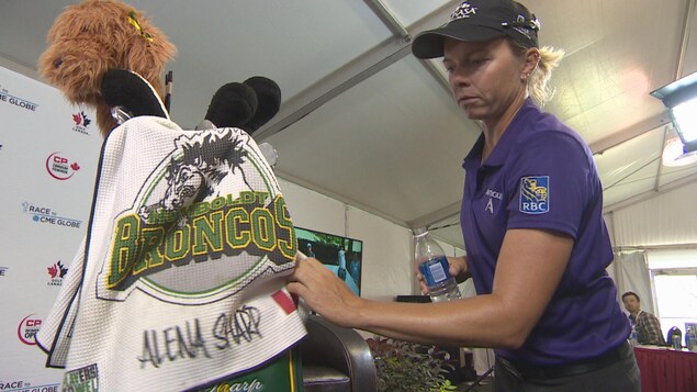 Alena Sharp replace une serviette portant le logo des Broncos de Humboldt sur son sac. Alena Sharp replace une serviette portant le logo des Broncos de Humboldt sur son sac.