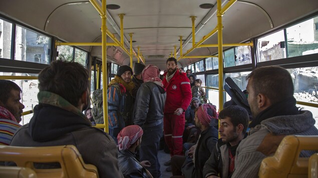 Du personnel du Croissant-Rouge syrien évacue en bus des combattants rebelles et leurs familles des quartiers d’Alep détenus par les rebelles. Du personnel du Croissant-Rouge syrien évacue en bus des combattants rebelles et leurs familles des quartiers d’Alep détenus par les rebelles.