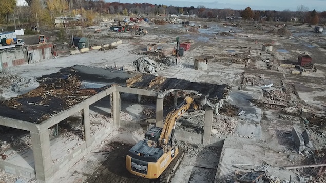 Des pelles mécaniques détruisent une usine abandonnée.