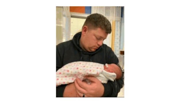 Un enfant dans les bras d'un parent.